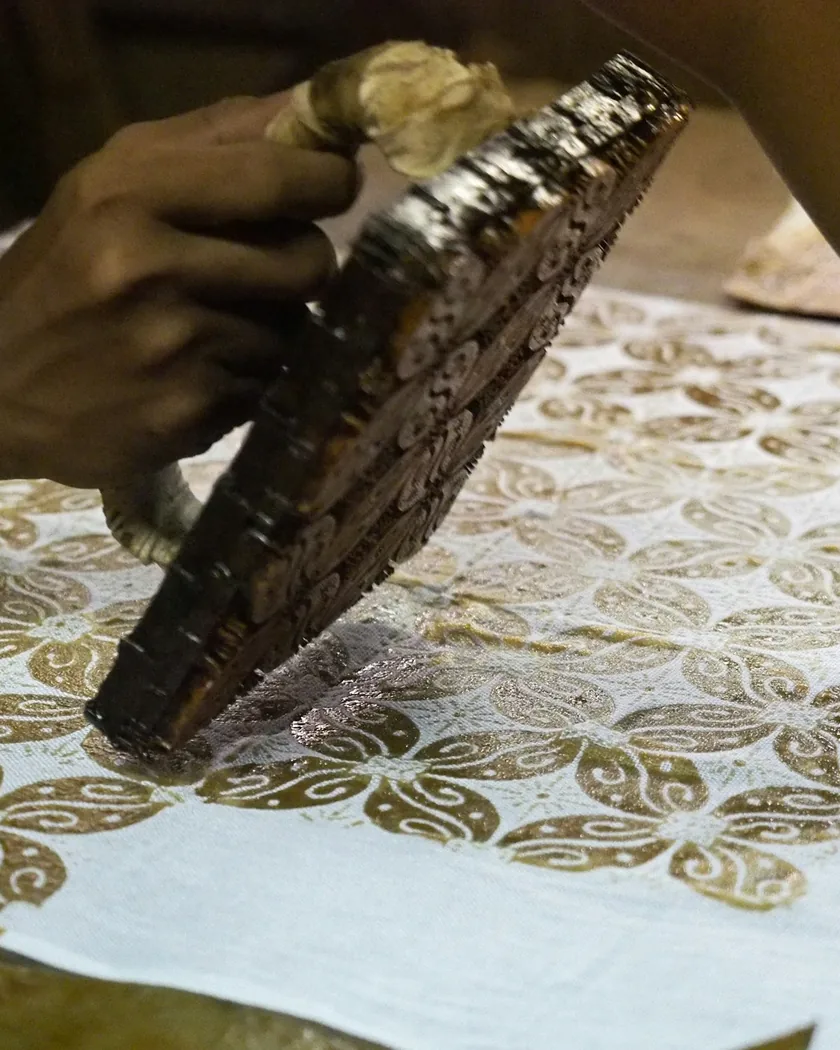 Taco de estampación sostenido en la mano, con el relieve del motivo hacia arriba